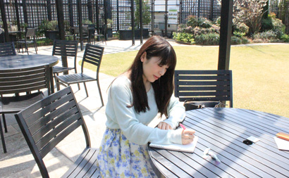 テーブルに座ってノートに書いている写真