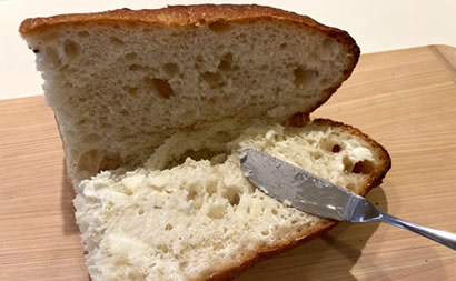 パンにバターを塗りこんでいる写真